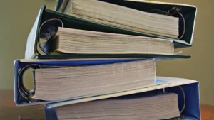 Stos segregatorów z dokumentacją na biurku