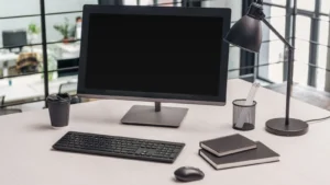 Stanowisko biurowe z monitorem, osobną klawiaturą i myszą oraz lampką na blacie